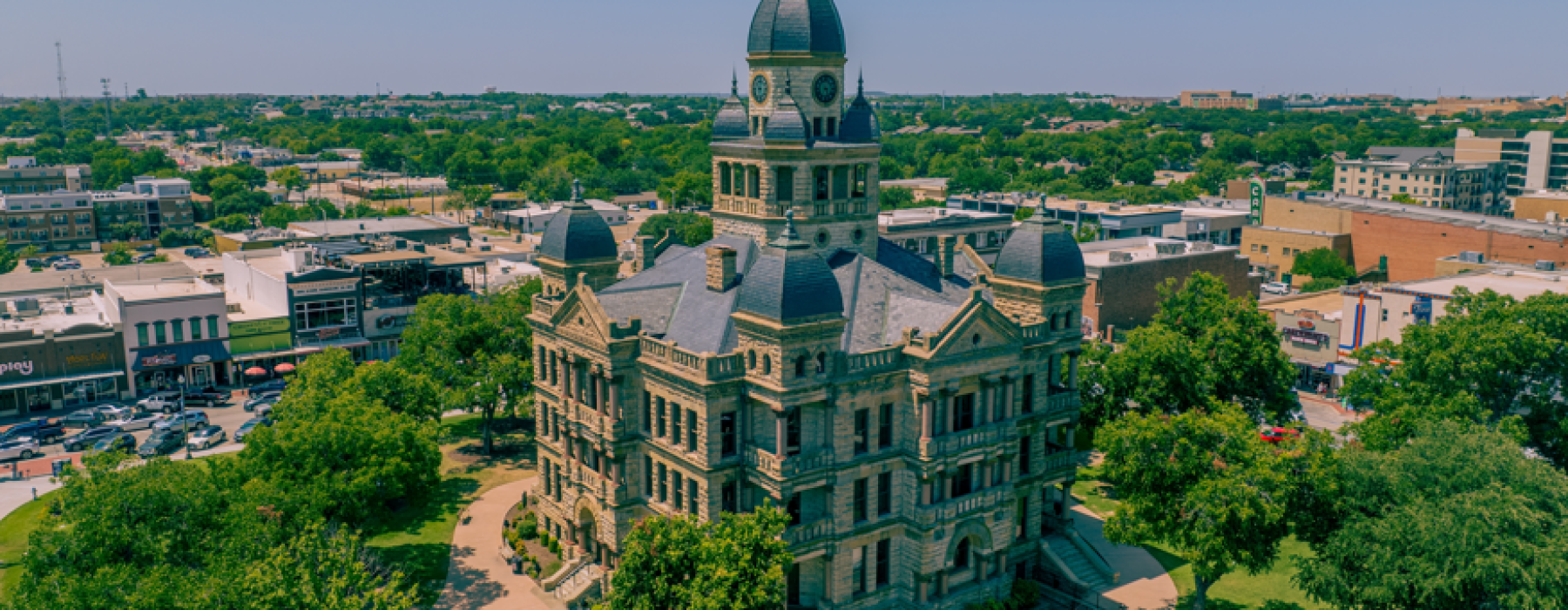 Aerial view of historic Denton County Courthouse clock tower and downtown square in Texas